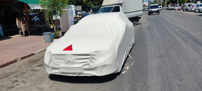 Sokakta park etmiş otomobilde beyaz araba kılıfı uygulaması – ANT BRANDA