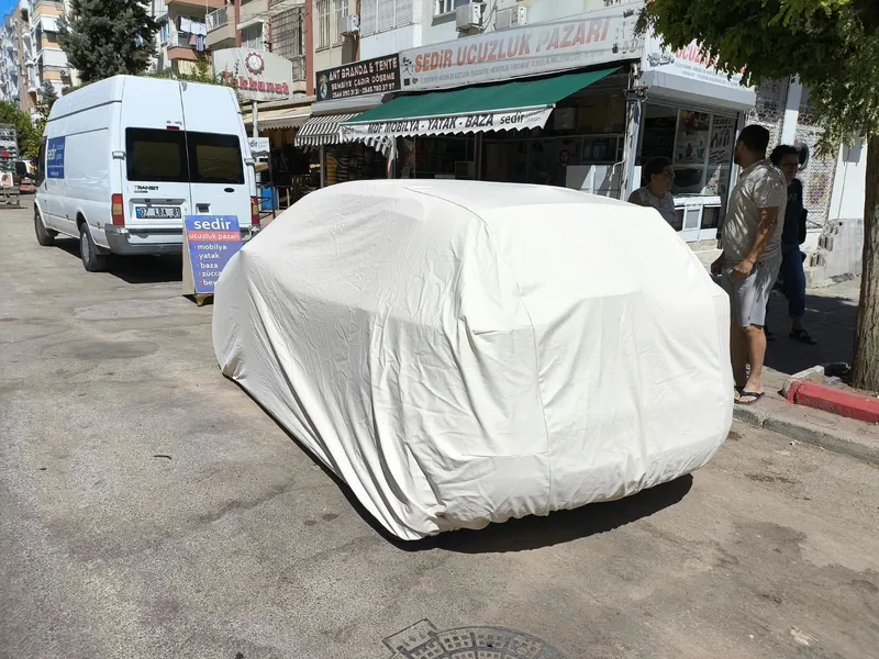 Cadde üzerinde beyaz araba kılıfıyla korunan araç – ANT BRANDA