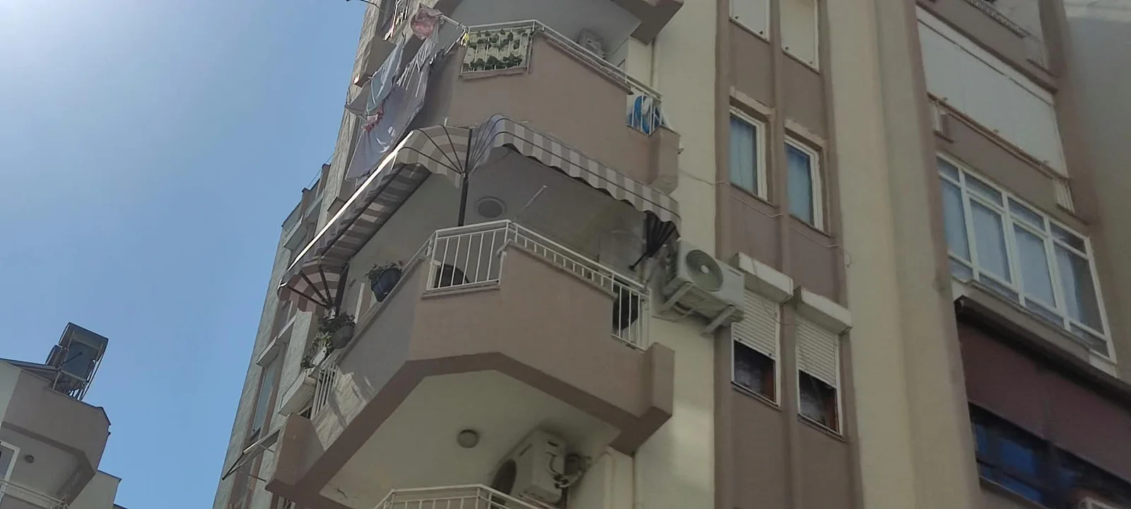 Apartman balkonlarında gri çizgili körüklü tente uygulaması – ANT BRANDA